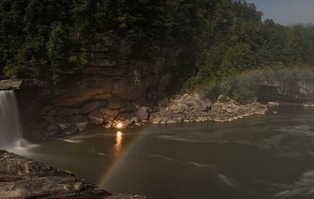 A pale moonbow arcing through mist at Cumberland Falls in Kentucky at night
