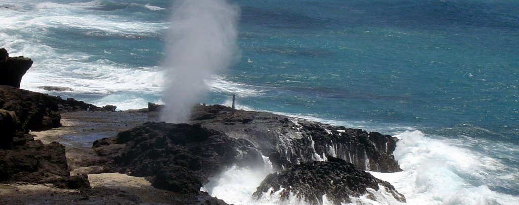 A plume of seawater erupts from Hālona Blowhole on Oʻahu’s rocky coast.