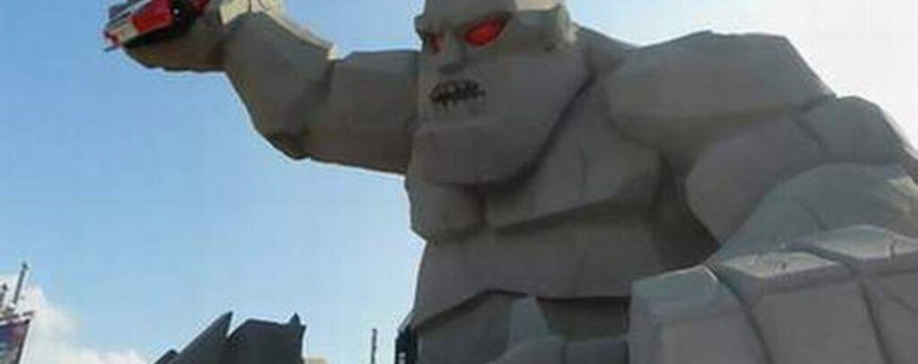 Miles the Monster holding a race car outside Dover Motor Speedway